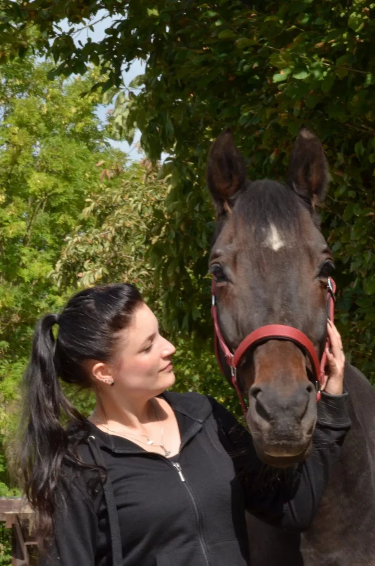Katja harmonisch zusammen mit ihrem Pferd auf der Koppel